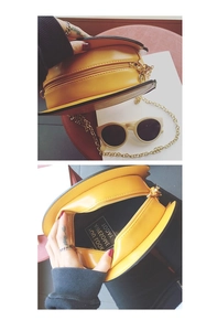 Close-up of mustard yellow burger-shaped crossbody bag with gold chain and interior view