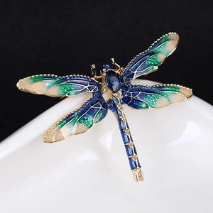 Detailed close-up of blue and green enamel dragonfly brooch with a large oval gemstone