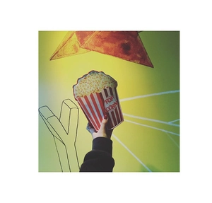 Detail of red and white striped popcorn clutch bag with POP CORN text and gold chain strap