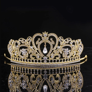 Détail de la couronne baroque dorée sertie de strass blancs sur fond noir profond
