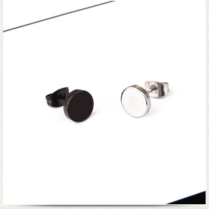 Macro shot of minimalist black and silver stainless steel stud earrings in disk design