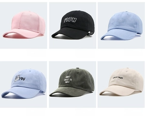 Dettaglio di cappellini da baseball in cotone ricamato nei colori rosa e nero