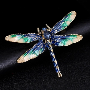 Detailed close-up of a blue enamel dragonfly brooch with sparkling rhinestones and gold alloy