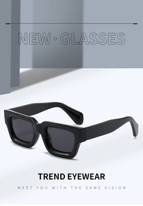 Detail view of bold black square frame sunglasses with thick temples and dark lenses