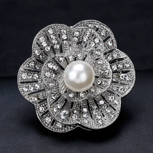 Elegant silver flower brooch with sparkling rhinestones and a large white center pearl