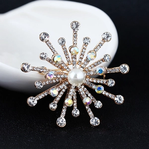 Detailed macro view of gold starburst brooch with central pearl and sparkling rhinestones