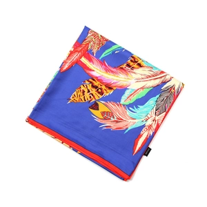 Gros plan d'un foulard 100% soie avec imprimé plumes et bordure rouge roulottée