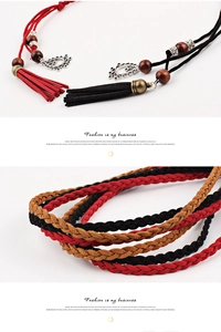 Detail of bohemian hand-woven waist chain with vintage silver charms and tassels