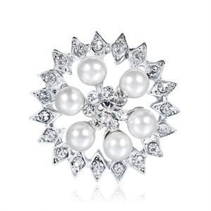 Macro shot of a silver brooch featuring white pearls and a sparkling diamond flower core