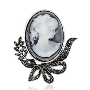 Detailed macro view of vintage cameo brooch with intricate silver floral metalwork