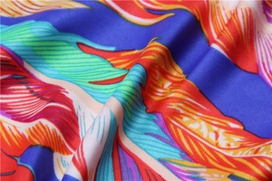Vue macro de l'écharpe en soie avec motifs de plumes colorées et texture tissée