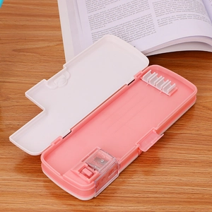 Pink double-layer cartoon pencil case with sharpener and slots on wooden desk