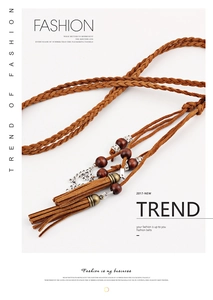 Detail of bohemian hand-woven waist rope with brown tassels, wood beads and metal charms