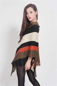 Detail of colorful striped knitted poncho featuring decorative fringe hem and soft fabric