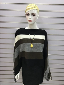 Detail of striped knitted poncho with fringe hem and long beaded necklace accessory