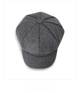 Overlooking display of a dark grey wool octagonal newsboy cap with top button detail