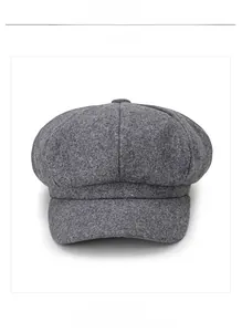 Detailed close-up of dark grey wool octagonal cap fabric texture and top button