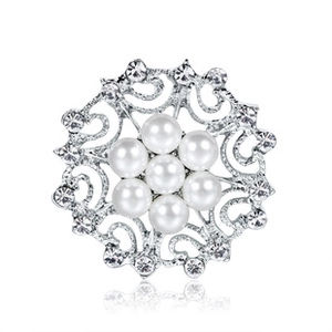 Detail of silver snowflake brooch featuring central pearls and sparkling crystal rhinestones