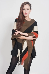 Detailed view of the bohemian tassel hem and striped knit pattern on the poncho wrap