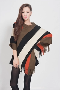 Close-up of fringe details on the striped knit poncho sweater featuring a colorful pattern