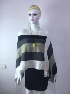 Detail of multi-color striped knitted poncho with fringe hem on a female mannequin