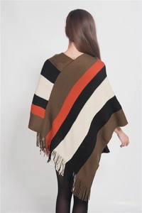 Rear view detail of a knitted striped poncho featuring stylish fringe hem and warm earthy tones