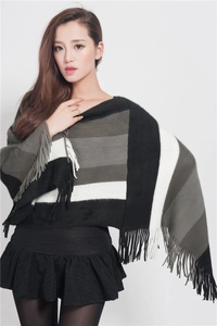 Detail shot of multicolor striped knit shawl with fringe hem and soft wool texture