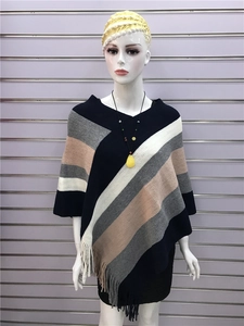 Detailed view of diagonal stripes and fringe hem on this stylish knit poncho