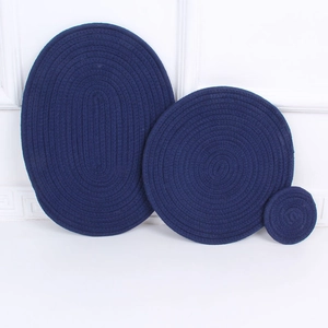 Close-up of 3-piece dark blue woven cotton placemat set with oval and round heat pads
