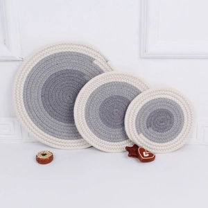 Three-piece set of woven cotton trivets in grey and white spiral pattern detail