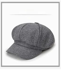 Close-up of grey wool octagonal newsboy hat with stitched panels and decorative top button