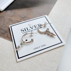 Detail of vintage 925 silver hoop earrings featuring punk cone spikes and engraved textures