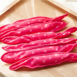 Pink polka dot sponge hair rollers set on a wooden tray for heatless wave styling