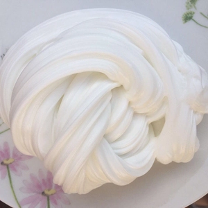 Close-up of white butter slime showing smooth creamy texture on floral plate
