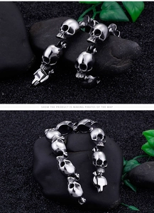 Detailed close-up of 3D skull charms and secure clasp on a punk titanium steel bracelet