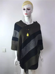 Detail of knit poncho fringe hem showing green and grey diagonal stripe texture