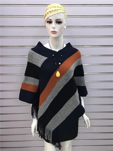 Close-up of color-block striped knit poncho with fringe hem and navy grey details