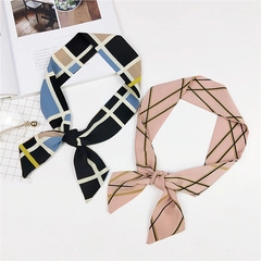 Primo piano di foulard a quadri blu-giallo e rosa-verde annodati in modo elegante