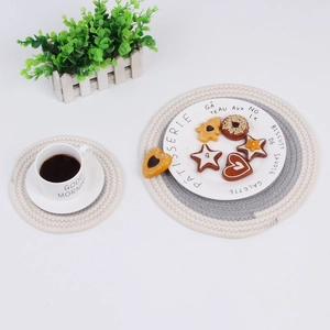 Flat lay of hand-woven cotton insulation mats in beige and grey for home dining decor
