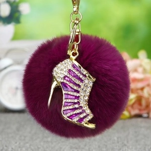 Détail d'un porte-clés pompon violet avec un charm de chaussure à talon en cristal