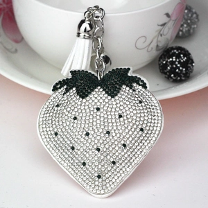 Detail of strawberry keychain with white rhinestones, silver alloy chain and white tassel