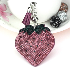 Close-up of strawberry rhinestone charm with pink crystals and purple tassel detail
