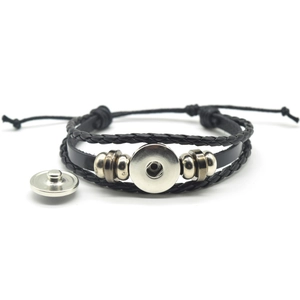 Detail of black braided leather steampunk bracelet with silver metal snap button