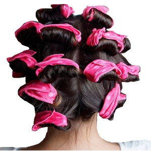 Detail of pink polka dot foam hair rollers applied on hair for heatless styling