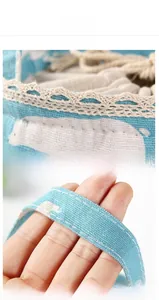 Detail of light blue linen bento bag with white polar bear print and beige lace trim
