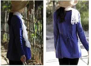 Detail of blue textured long sleeve top paired with white lace embroidered scarf outdoors