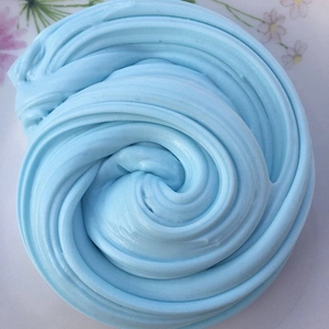 Detailed view of light blue butter slime showing smooth spiral swirl texture and soft finish