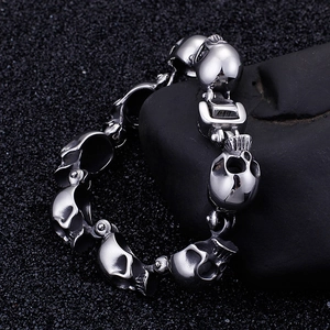 Punk style titanium steel bracelet featuring 3D skull charms with a polished silver finish