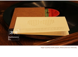 Detailed view of DIY heart cross-stitch kraft card with hollow pattern on vinyl record