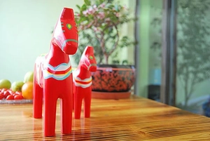 Detail of red wooden Dala horses with hand-painted floral patterns for home decor